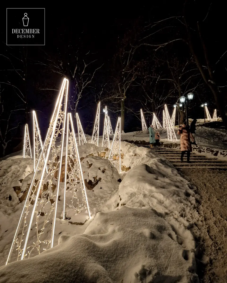 Light cones in a row along the snowy stairs on a winter evening, visitors walk up them