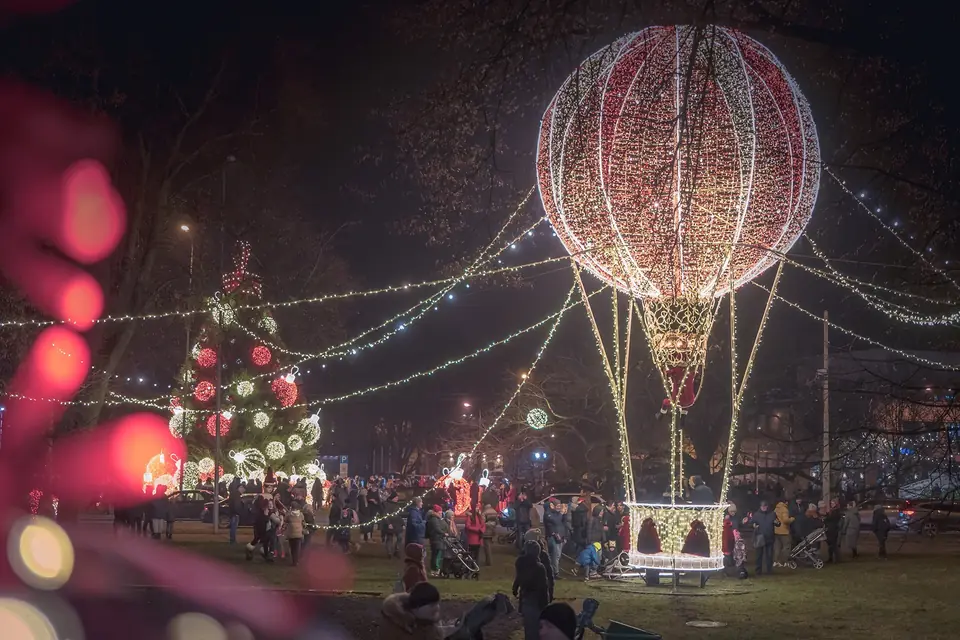 A large light balloon sculpture of Santa Claus at a public event