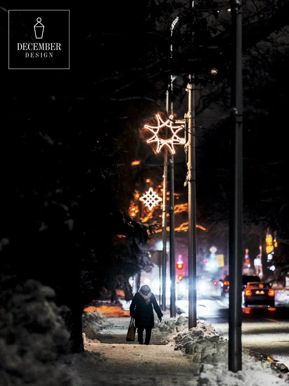 Star-shaped light decorations on street lamps on a snowy street at night