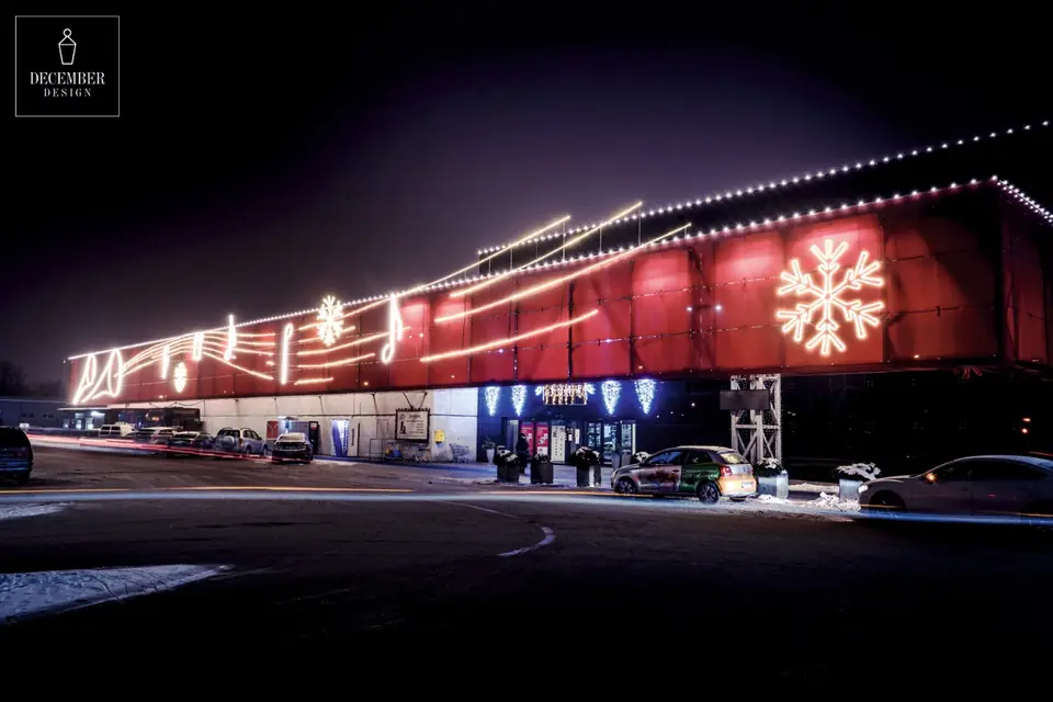 Tilžė shopping centre entrance with conical lights hanging under the eaves and two snowflakes