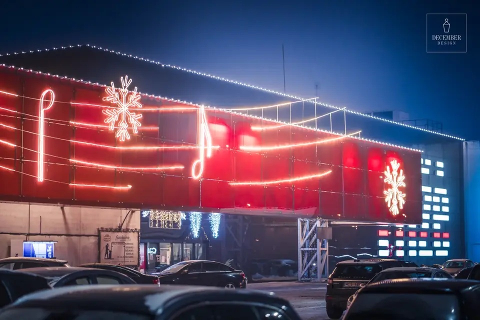 Section of the Tilžė shopping centre red facade with music lines, notes and snowflake light decorations