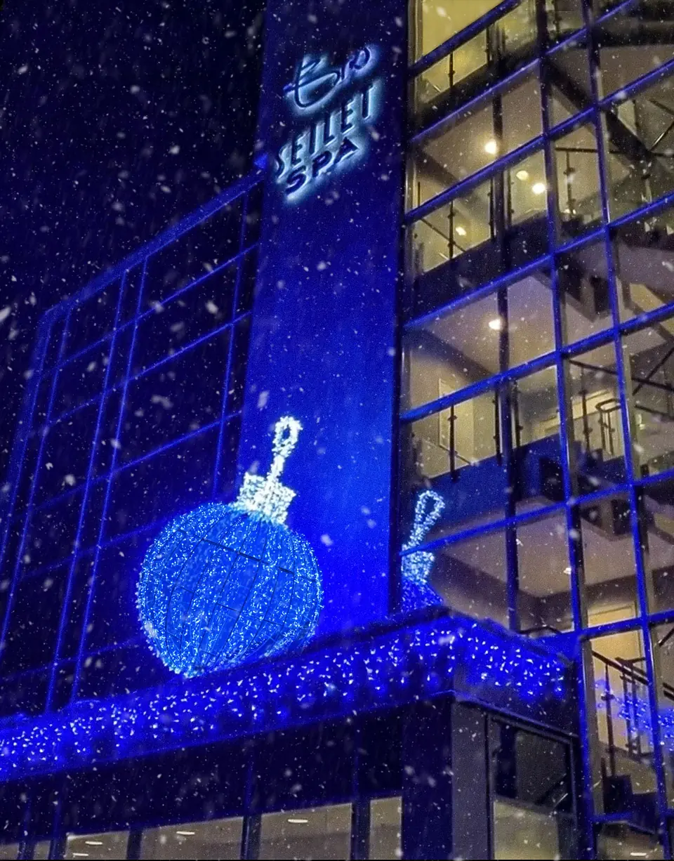 Blue Christmas light decoration on building facade in Molde, Norway during snow