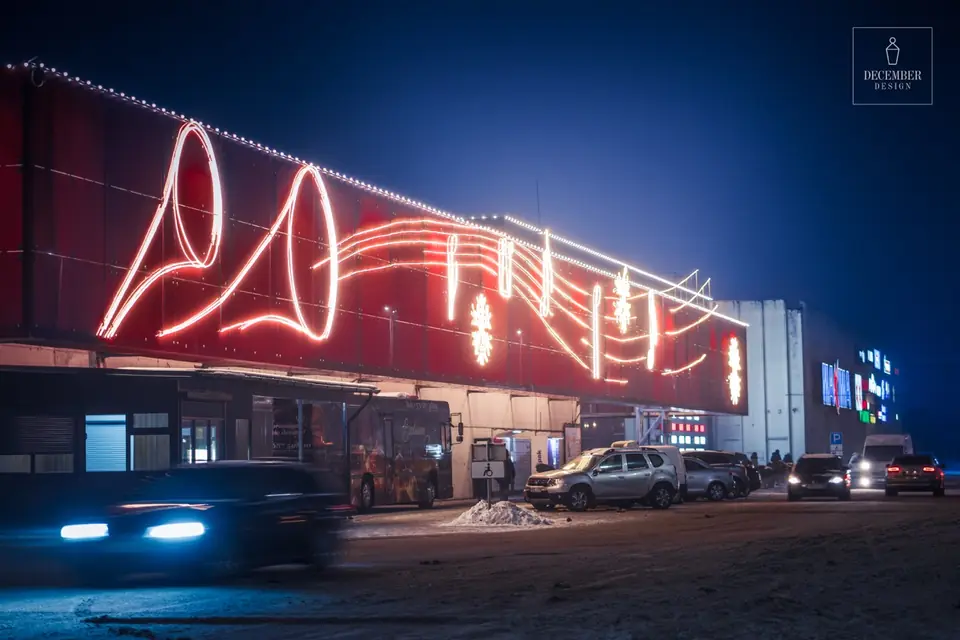 Tilžė shopping centre facade at night with musical motif light decorations - horns, musical notes and snowflakes