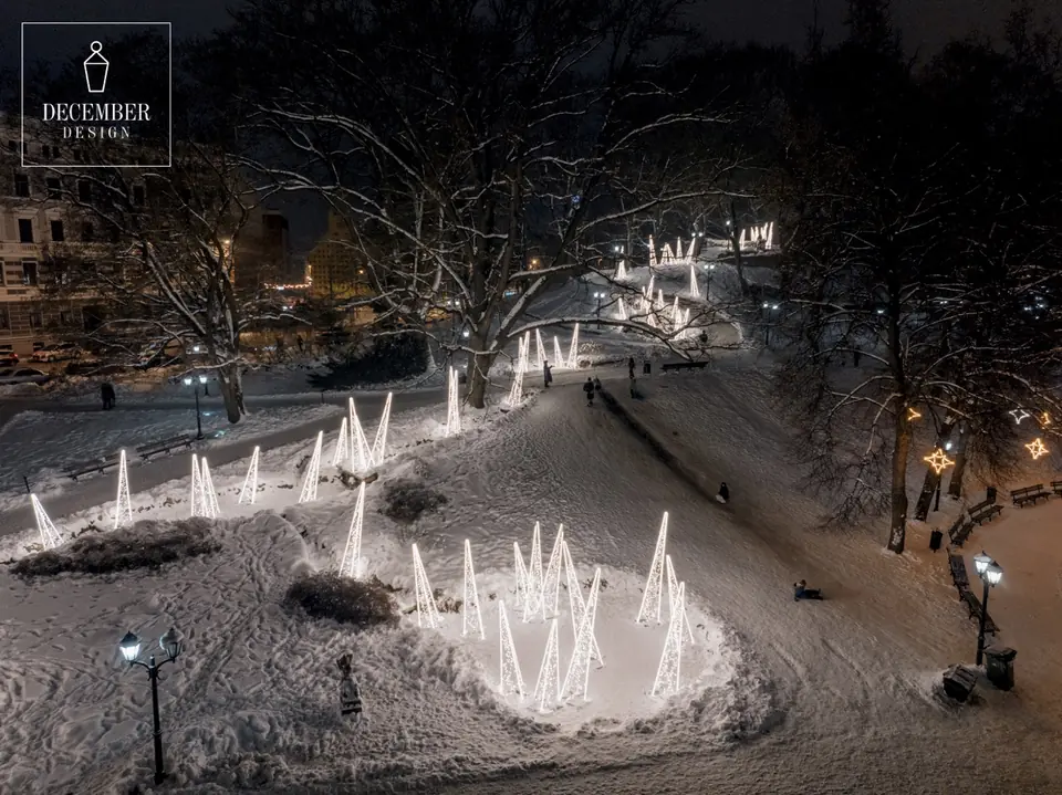 Bird's-eye view of the Trail of Light Cones - a white path of light winds through a snowy park